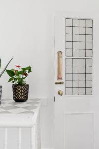 a white door with a potted plant on a table at Stunning Victorian property near Canary Wharf! in London