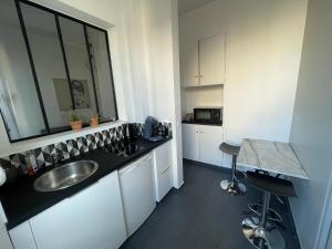 a small kitchen with a sink and a counter at Studio Cosy 2 adultes in Reims
