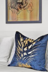 Stunning Victorian property near Canary Wharf! في لندن: وسادة زرقاء موضوعة على سرير مع صورة