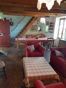 RoussonにあるGîte - Mas de Louiseのリビングルーム(赤いソファ、テーブル付)