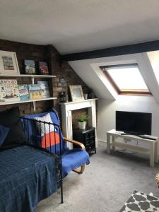 a attic room with a bed and a television at Quirky Loft Apartment in Paignton with sea views in Paignton