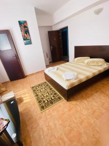 1 dormitorio con 1 cama grande y suelo de madera en Casa Ana, en Bucarest