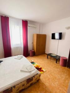 a bedroom with a bed and a table and a window at Casa Ana in Bucharest