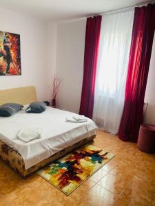 a bedroom with a bed with red curtains and a rug at Casa Ana in Bucharest