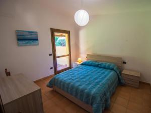 Residence Cala Petralana في بورتو بولو: غرفة نوم مع سرير وبطانية زرقاء