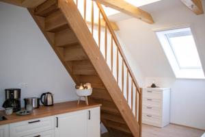 un escalier dans une cuisine avec des placards blancs et une fenêtre dans l'établissement Rooms Močilnik, à Begunje na Gorenjskem