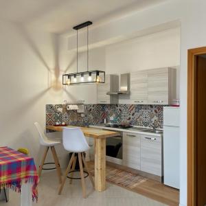 eine Küche mit einem Holztisch und weißen Schränken in der Unterkunft Zà Lisa in San Vito lo Capo