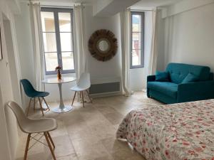 a bedroom with a bed and a table and a couch at Maison Delière in Venterol