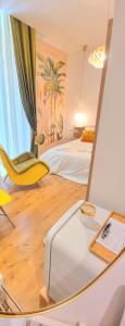 una camera da letto con specchio, letto e sedia di Napoli Tree - Lungomare a Napoli