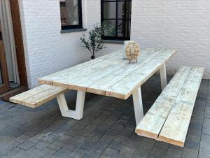 een houten picknicktafel en 2 banken op een patio bij Vakantiewoning Spoor 23 in Borgloon