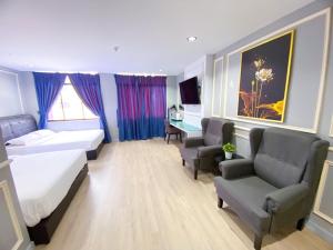 a hotel room with a bed and chairs and a desk at 61 Hotel in Gua Musang