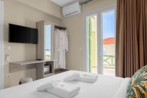 a bedroom with a bed with a view of the ocean at Corali Suites Andros in Batsi