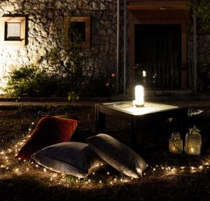 a table with a candle and pillows on the ground with lights at Casa Di Pietra in Fethiye