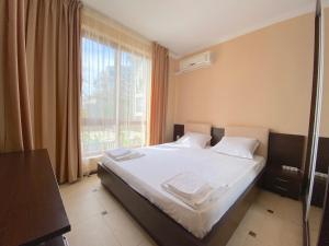 1 dormitorio con 1 cama con sábanas blancas y ventana en Tryavna Beach - Private Apartment - BSR en Sveti Vlas