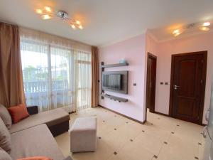 a living room with a couch and a tv at Tryavna Beach - Private Apartment - BSR in Sveti Vlas