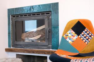 a person wearing colorful socks sitting next to a fireplace at Uroczy Apartament Muszynka in Muszynka