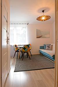 a living room with a table and a couch at Uroczy Apartament Muszynka in Muszynka