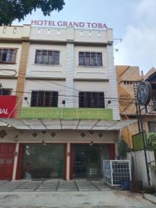 a building with a hotel grand tours sign on it at GRAND TOBA HOTEL in Balige