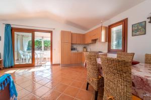 une cuisine et une salle à manger avec une table et des chaises dans l'établissement House in San Teodoro among the scents of Sardinia, à San Teodoro 3 autres photos