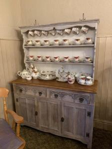 a wooden dresser with a lot of dishes on it at The Lampet Arms in Banbury