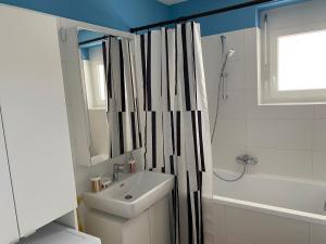 a bathroom with a sink and a shower curtain at Brand New Cozy Apartment 10 min to city center in Vienna