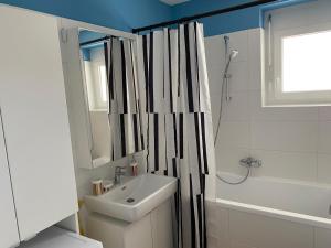 bagno con lavandino e tenda doccia di Brand New Cozy Apartment 10 min to city center a Vienna