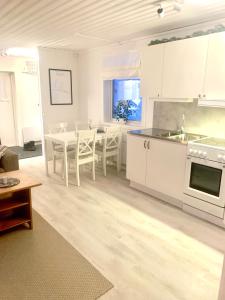 - une cuisine et une salle à manger avec des placards blancs et une table dans l'établissement 1125 Fjällstugan, à Lofsdalen