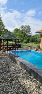 a swimming pool with a gazebo next to at OAZA in Mokra Gora