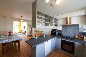 a kitchen with white cabinets and a table in a room at L'Autre Pavillon in Cholet