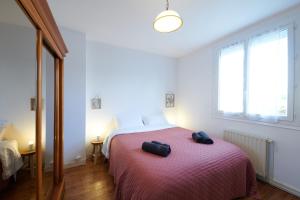 a bedroom with a bed with two black bags on it at L'Autre Pavillon in Cholet