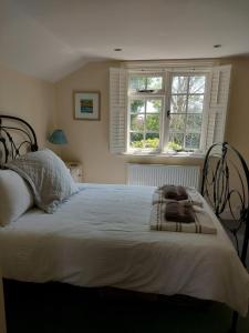a bedroom with a large white bed with two windows at The seaside retreat in Kent