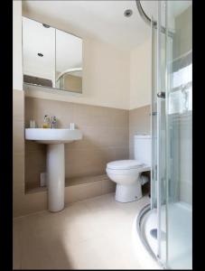 W łazience znajduje się umywalka, toaleta i lustro. w obiekcie The seaside retreat w mieście Kent