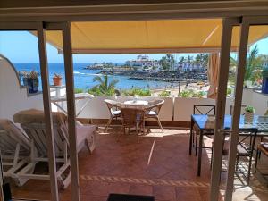 un patio con tavolo, sedie e vista sull'oceano di Mogán suite a Puerto de Mogán