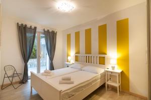 a bedroom with a bed and yellow and white stripes at Villa Kiara in Torri del Benaco +80 photos