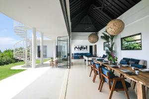 an open living room with a long dining table and chairs at Villa Paradise Uluwatu in Ungasan