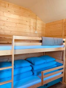 two bunk beds in a cabin with blue pillows at Domki Letniskowe ARTEMI in Rowy
