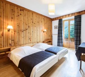 1 dormitorio con paredes revestidas de madera y 1 cama en Grand Hôtel & Kurhaus, en Arolla
