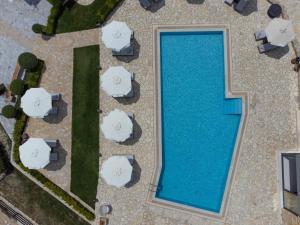 an overhead view of a swimming pool with white umbrellas at Tramonto Suites in Xi
