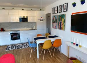 eine Küche mit einem Tisch und Stühlen sowie einem TV in der Unterkunft Brand New Cozy Apartment 10 min to city center in Wien