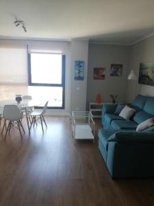 sala de estar con sofá azul y mesa en Apartamento Teatinos Málaga, en Málaga