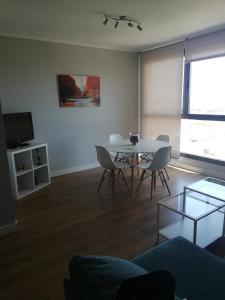 a living room with a table and chairs and a tv at Apartamento Teatinos Málaga in Málaga