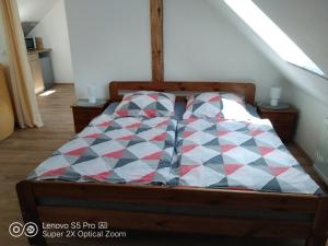 a bed with a checkered comforter in a bedroom at Wellness apartmán Beavital in Dolany