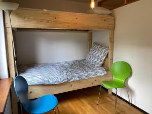 a bedroom with a bunk bed and two chairs at Haus Dreil in Ober-Abtsteinach