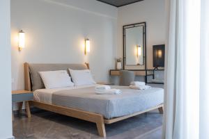 een slaapkamer met een bed met twee handdoeken erop bij Tramonto Suites in Xi