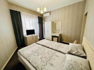 a hotel room with a bed and a television at Джорджия in Kiten