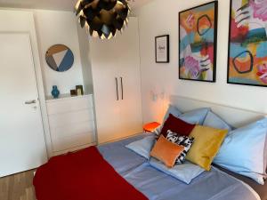 a bedroom with a bed with colorful pillows on it at Brand New Cozy Apartment 10 min to city center in Vienna