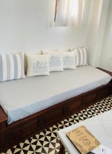 una cama con almohadas blancas en una habitación en Palazzo Arhontiko Apartments, en Agios Nikolaos