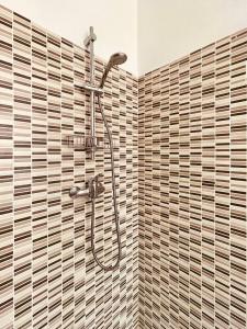 a shower in a bathroom with brown tiles at Casa La Palma in Verbania