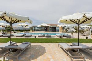 a group of chairs and umbrellas next to a pool at Tramonto Suites in Xi