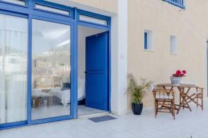 a blue door leading to a patio with a table at Mourayio Apartments in Pomos